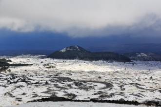 Wide, rugged lava field with volcanic cones, snow debris, curved road, Etna, Etna, Catania, Sicily,