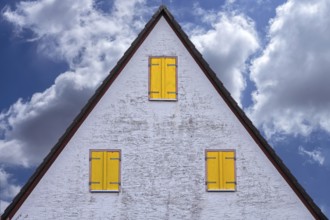 Old gable of a farmhouse with yellow shutters, cloudy sky, Beerbach, Middle Franconia, Bavaria,