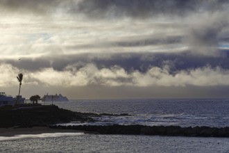 Dramatic scenery with clouds over the sea and a distant ship, Playa Blanca Lanzarote