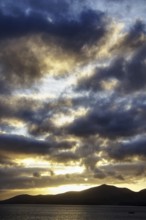 Dramatic sky during sunset, mountains in silhouette, light shows in the clouds, Puerto del Carmen