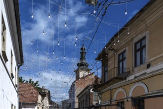 Light bulbs between houses for evening lighting, Cluj-Napoca, Transylvania, Romania