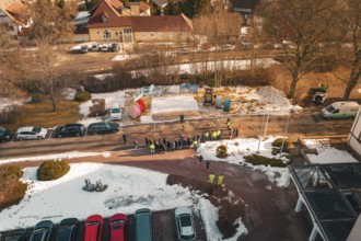 People standing in a wintry environment with cable drums, from a drone perspective, fiberglass