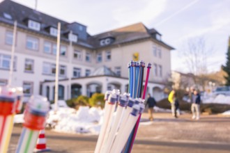 Colourful bundles of cables in front of a building, with snow-covered floor and people, fibreglass