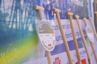 Row of shovels in front of an information poster at a symbolic event, fiberglass groundbreaking,