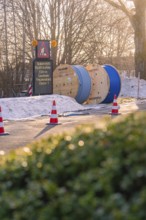 Cable drums and traffic cones on a construction site in the snow at sunrise, fibreglass