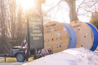 Two rolls of cable next to a glowing construction site sign in a winter environment, fibreglass