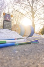 Colored cables in front of cable rolls in sunlight along a snowy road, fiberglass groundbreaking,