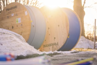 Cable drums in the snow, steeped in warm morning light, create a wintry atmosphere, fibreglass