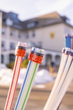 Colourful cables with coloured connectors in front of a blurred building, fibre-optic
