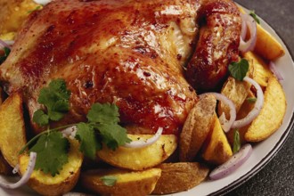 Fried, baked chicken, in the oven, with spices, and rustic potatoes, top view, homemade