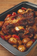 Pork knuckle, baked with vegetables, new potatoes, on a baking sheet, homemade, no people
