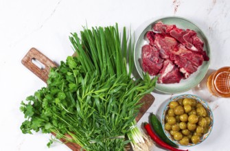 Ingredients for cooking chakapuli, canned tkemali, meat, herbs Georgian cuisine, top view