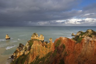 Rocky coast with storm cloud, Praia do Camilo, Lagos, Algarve, Portugal