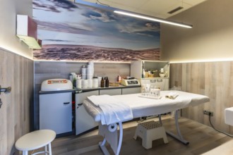 Professional beauty salon interior featuring a comfortable treatment bed, various skin care