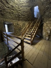 Modern wooden staircase for visitors tourists in keep made of quarry stone masonry Castle tower of