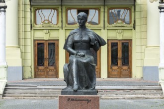Statue of Ukrainian National Poet Olga Kobyljanska, in the back the Olha-Kobylianska Theatre,