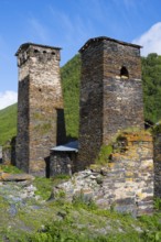 Two restored stone towers surrounded by nature and blue skies, defensive towers, Ushguli, Murqmeli