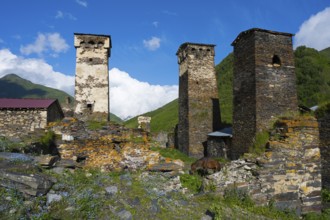 Historic stone towers of a mountain village under clear blue sky, defensive towers, Ushguli,