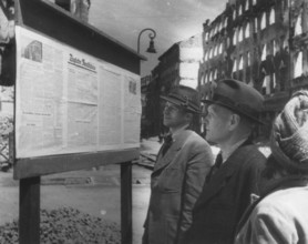 Readers stand in front of the 'Daily Rundschau' notice. The Daily Review was a newspaper published