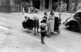 Civilians, two woman and their children with trolleys, Berlin at the beginning of May 1945, Germany