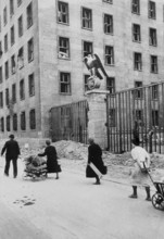 Civilians walk with their belongings in front of the Reich Ministry of Aviation in Wilhelmsstraße,