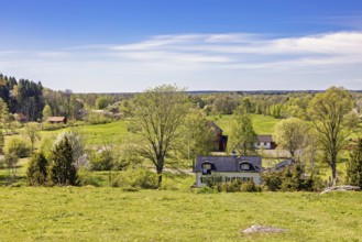 Beautiful landscape view with meadows and fields and residential houses in the countryside on a