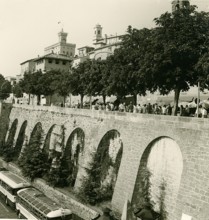 Historic city wall with tourists and historic buses, photo taken in summer 1961, San Marino, Italy