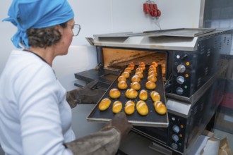 A baker pushes a sheet of golden rolls into the oven, bake rolls, Haselstaller Hof, Gechingen,