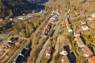 Aerial view of a small village with forest and railroad tracks, test run on the new Hermann-Hesse