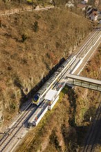 Aerial view of a train near a bridge in a hilly landscape, test run on the new Hermann-Hesse