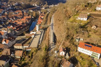 Train route through hilly village with red roofs and a river, test trip on the new Hermann-Hesse