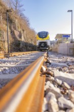 Close-up of a modern train on gravel tracks in sunlight, test run on the new Hermann-Hesse railway