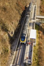 Train stops at a station in the rocky hills, viewed from above, test run on the new Hermann-Hesse