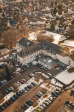 An overview of a building with addresses, parking lot and light snowfall, District Office,