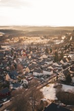 A landscape view of a village at sunset in winter with snow-covered roofs, Freudenstadt, Black