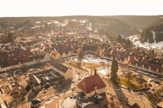 Panoramic view of an old town with distinctive church and snow-covered roofs in winter light,
