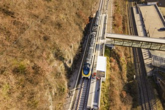 Bird's-eye view of a train station with bridge and autumnal tracks, test run on the new
