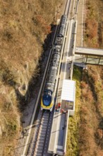 Bird's eye view of a train at a station in an autumn landscape, test trip on the new Hermann-Hesse