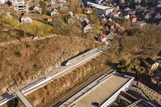 Houses and urban structure on hilly landscape with train on tracks, test run on the new