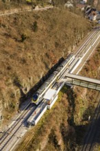 Vertical view of a train station with bridge surrounded by autumn landscape, test run on the new