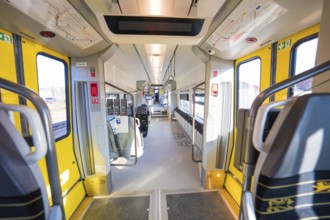 Modern interior of a train with yellow doors and panoramic windows, test run on the new