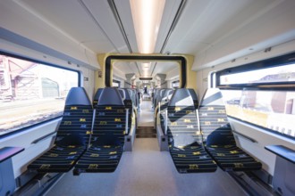 Modern train design with yellow accents and bright window light, test run on the new Hermann-Hesse