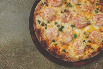 Four cheese pizza with shrimp and fresh microgreens, served on a wooden board, homemade, no people