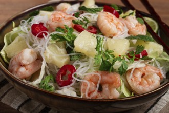 Thai salad with shrimp and rice noodles, pineapple slices, coriander and mint leaves, homemade, no