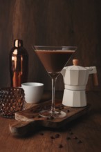 Espresso martini cocktail, alcoholic drink, shaker and geyser coffee maker, on a wooden background