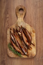 Cold smoked capelin, on a wooden chopping board, no people