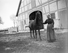 Woman with horse posing for the photo, farm, ca. 1920-1930, retro, vintage, old, historic, northern