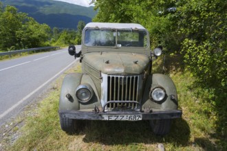 Front view of an old off-road vehicle on the side of the road in a rural setting, four-wheel drive