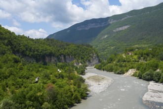 River flows through a wooded valley in the mountains under a cloudy sky, Rioni river near Alpana,