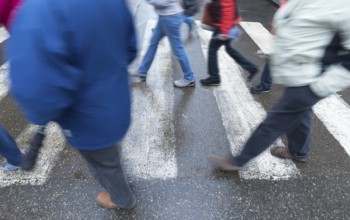 Pedestrians walk across zebra crossings, motion blur, Krakow, Poland